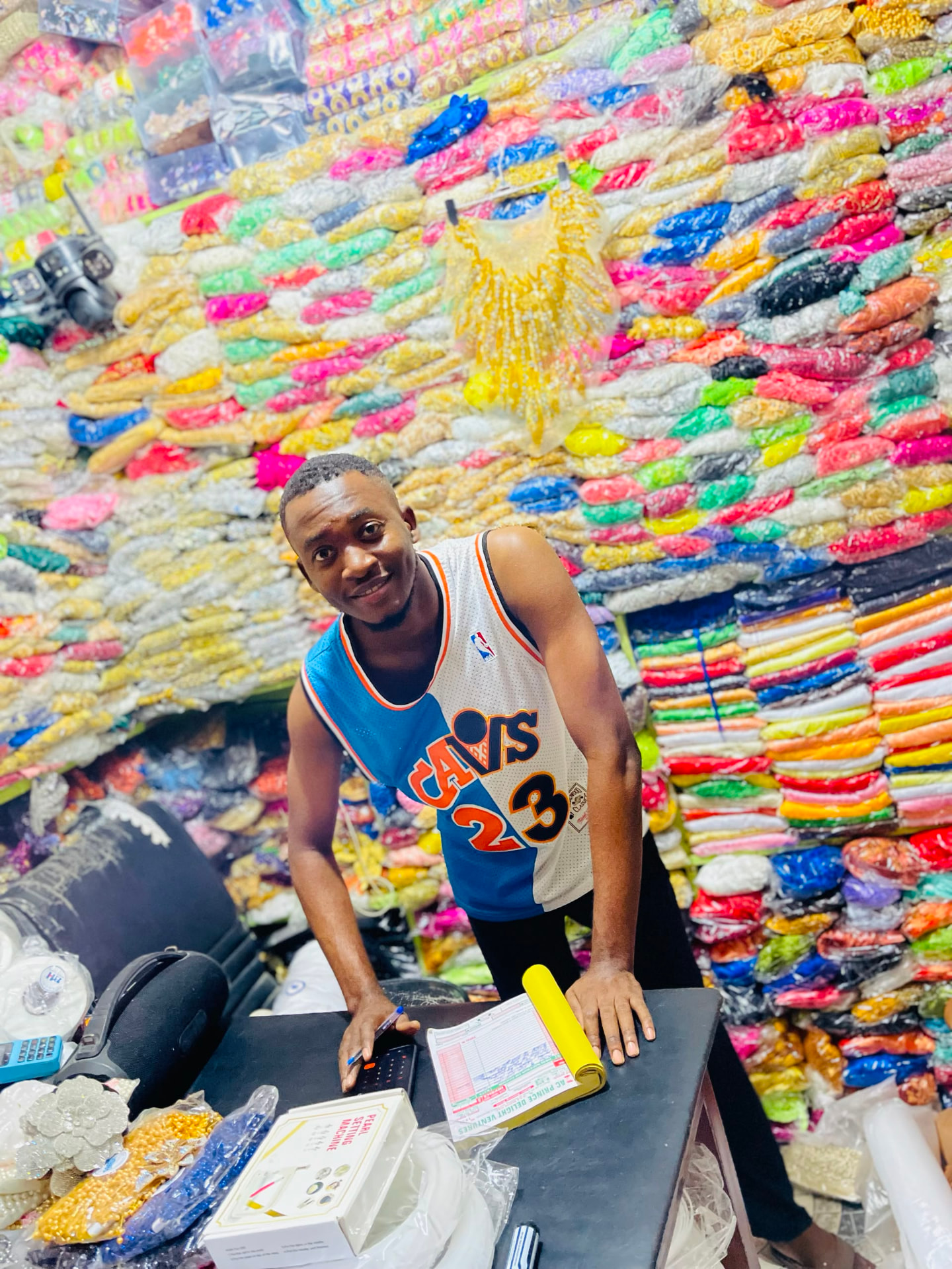 Inside AC Prince Delight's shop, surrounded by colourful embellishments