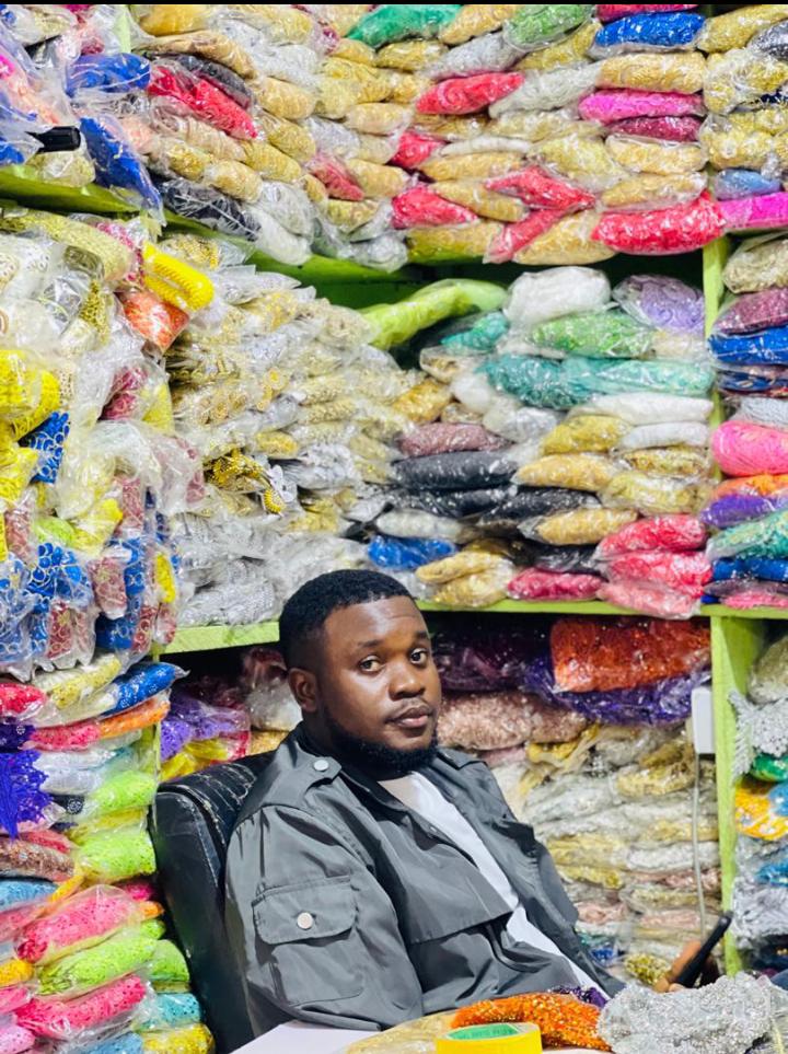Prince seated in the shop surrounded by colourful appliqués and embellishments